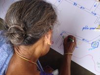 Photograph of a woman participating in a public participatory mapping project in India.