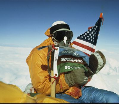 Mount Everest, Nepal. May 1, 1963, James Whittaker, the first American to summit Mount Everest, poses with the United States and National Geographic flags.